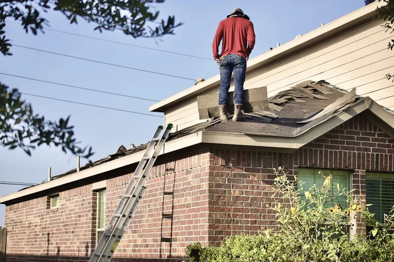 Professional roofer working on a residential roof in Cool Spring-Tilton Park